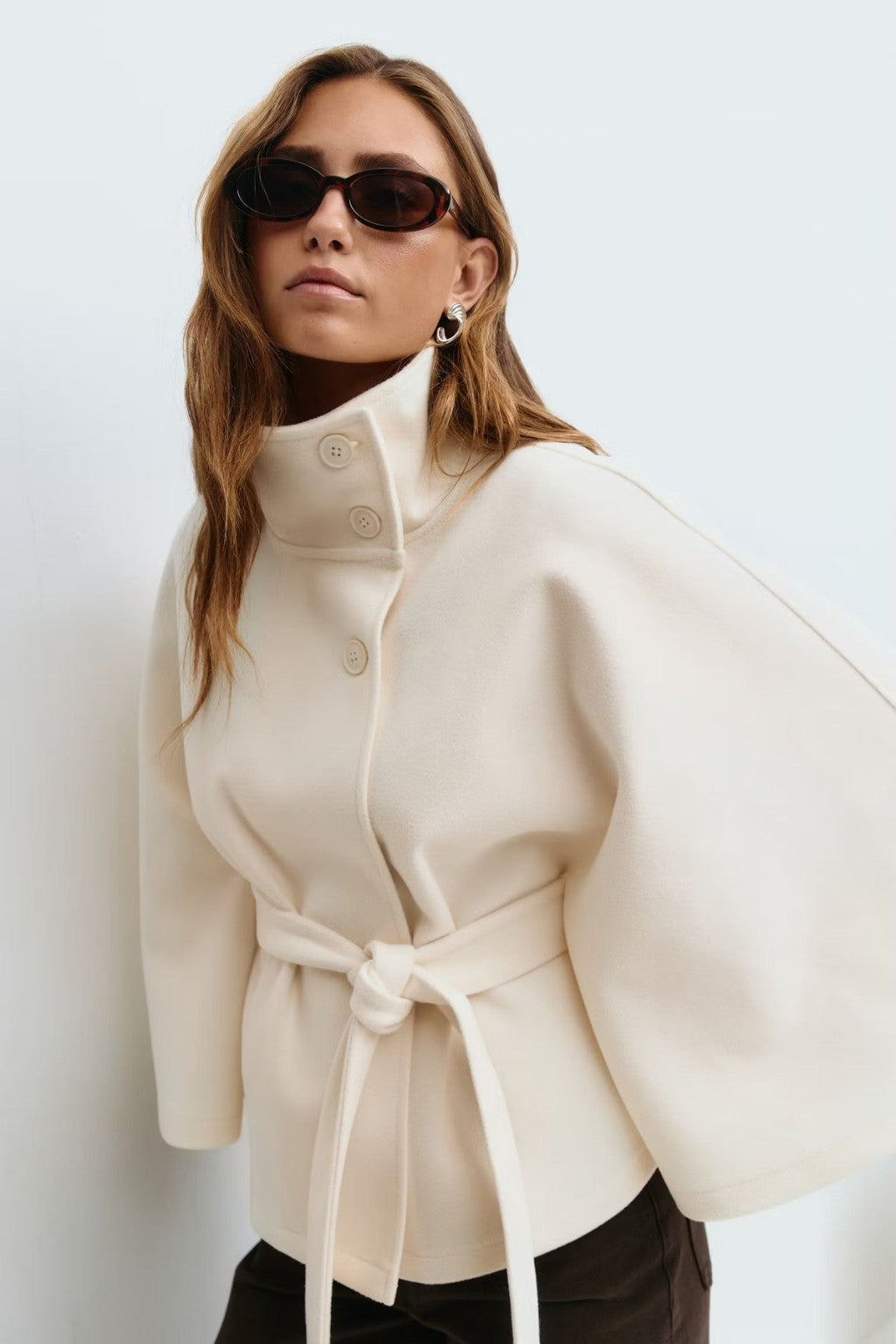 Model wearing the JANT belted poncho cape in white